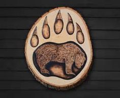 a bear's paw with drops of water on it and an image of a bear in the center