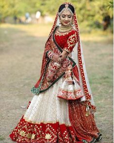 a woman in a red and white bridal outfit is walking down the road with her hand on her hip