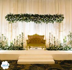 a chair sitting on top of a white platform in front of a floral covered wall