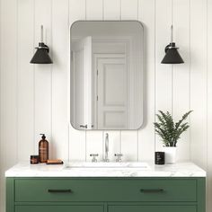 a bathroom vanity with green drawers and a large mirror above it, along with two black lamps