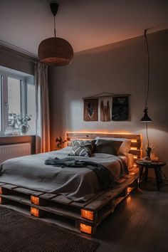 a large bed sitting in a bedroom next to a window with lights on the sides