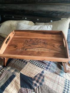 a wooden tray sitting on top of a bed