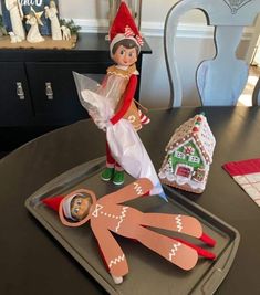 an elf is sitting on top of a tray with scissors and other items around it