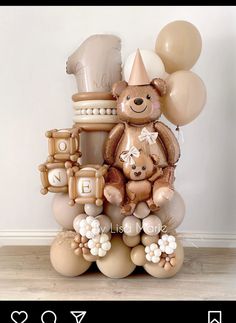 a teddy bear sitting on top of balloons