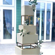 a three tiered cake with white flowers on it