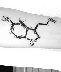 a black and white photo of an inked arm with the chemical symbol on it