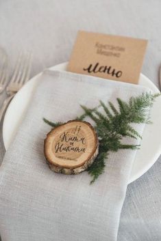 a place setting with silverware, napkins and wood slices on a white plate