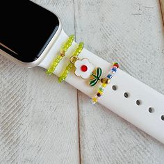 an apple watch is decorated with beads and flowers