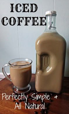 iced coffee in a glass mug next to a jug of liquid on a wooden table