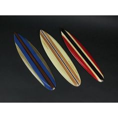 three surfboards sitting side by side on a black surface, one with red, white and blue stripes