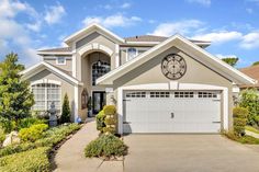 a large house with a clock on the front of it's face and driveway