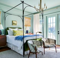 a bedroom with four poster bed and green walls