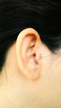 a close up of a person's ear with a piercing