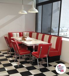 a dining room table with red chairs and a checkered black and white tile floor