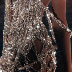 the back of a woman's dress covered in sparkling sequins and beads