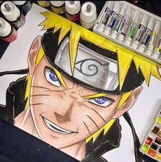 a drawing of naruto is shown on the table next to some paint and markers