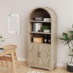 a living room with a chair, table and bookcase on the floor next to a potted plant