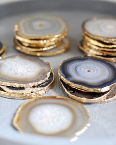 some gold and black agate stone coasters on a white plate with the words messages written below them