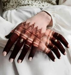 a woman's hands with henna tattoos on them