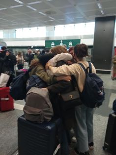 several people hugging each other in an airport