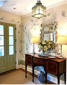 a room with a table, mirror and lamp on it in front of a door