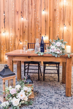 a wooden table with candles and flowers on it