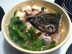 a bowl filled with fish and vegetables on top of a stove