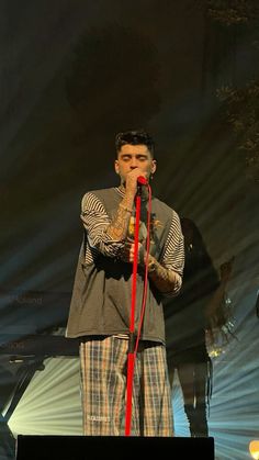 a man standing in front of a microphone on stage