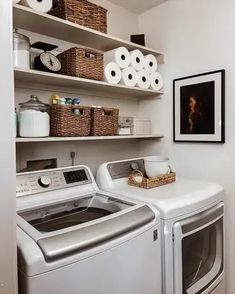 a washer and dryer in a small room with open shelving on the wall