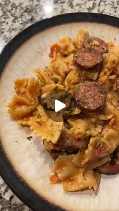 a white plate topped with pasta and sausage