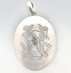 "An impressive, large, antique oval locket crafted in silver, the front of which has been hand-engraved with the monogrammed initials \"NS\" or \"SN\". A fantastic late Victorian or early Edwardian era piece which looks great paired with a thick silver chain. Circa 1895. Unmarked, tested as silver. The locket measures approximately 65mm (L) x 40.4mm (W). The approximate weight is 32.5 grams. Please note that the chain pictured is for display purposes only. Thank you. CONDITION: In very good antique condition with some light surface wear commensurate with age. The locket opens and closes as it should. LAYAWAY: We happily offer layaway/deposits on the majority of our items. Please send us a message if you would like to arrange a layaway. Layaways are not available on sale items. SHIPPING: Al Ornate Engraved Locket Necklace For Formal Occasions, Vintage Oval Jewelry With Engraving Option, Ornate Engraved Locket Necklace For Formal Events, Formal White Gold Engraved Locket Necklace, Classic Engraved White Gold Locket Necklace, Vintage Sterling Silver Oval Locket Necklace, Vintage Oval Sterling Silver Locket Necklace, Victorian Engraved Oval Cabochon Jewelry, Classic Oval Locket Necklace With Engraving