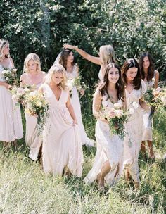 the bridesmaids are walking through tall grass