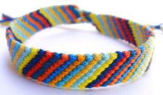 a multicolored bracelet is shown on a white surface with a string attached to it