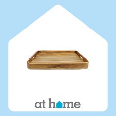 a wooden tray sitting on top of a blue and white background with the words at home above it