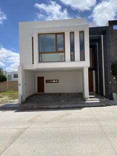 a white house with brown doors and windows on the side of it's face