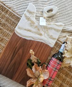 a wooden cutting board sitting on top of a table next to a bottle of wine