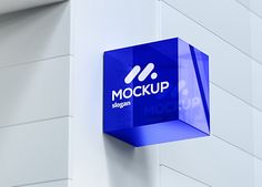 a blue sign hanging from the side of a white brick building that says mockup