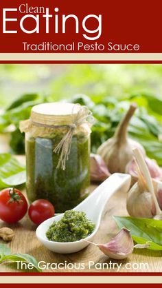 garlic and pesto in a jar on a wooden table next to tomatoes, garlic cloves and garlic breadcrumbs