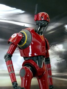 a red robot standing in front of a silver background