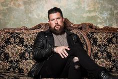 a man with a beard sitting on a couch