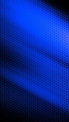 a blue light shining on the side of a black wall with hexagonal pattern