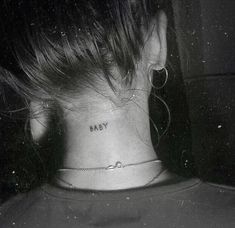 a black and white photo of a woman's neck with the word baby tattooed on it