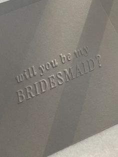 the words will you be my bridesmaid are etched onto metal sheets on a table