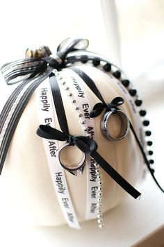 a white ball with black ribbon and two rings on it sitting on top of a window sill