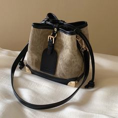 An elegant lingering sound that transcends the times. A bucket bag that can hold your smartphone, wallet, and makeup pouch. The combination of the dark and light body and the jet black leather is exquisite. The decorated leather tag adds a touch of playfulness. You will be fascinated by the delicate details. 
 
 
 Size 
 
 
 FREE size 
 
 Height: 16.5cm 
 Width: 17cm 
 Depth: 11cm 
 
 
 
 
 
 Material 
 
 Leather 
 Rayon Large Capacity Evening Bucket Shoulder Bag, Elegant Bucket-style Phone Bag, Evening Bucket Shoulder Bag With Large Capacity, Evening Large Capacity Bucket Shoulder Bag, Black Large Capacity Pouch Bucket Bag, Black Bucket-shaped Bags For On-the-go, Black Bucket Bags For On-the-go, Chic Large Capacity Black Phone Bag, Beige Bucket Bag With Large Capacity For Evening