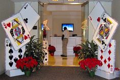 a man standing in front of an entrance decorated with playing cards and red carnations