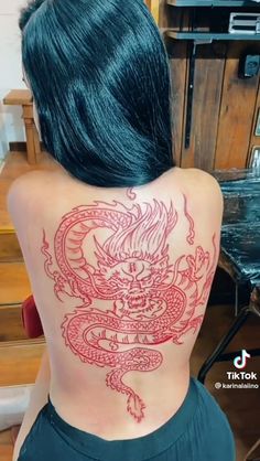 a woman with a dragon tattoo on her back