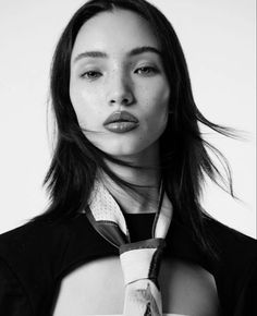 a black and white photo of a woman wearing a neck tie