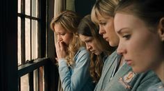 four women are looking out the window at something