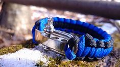 a blue and black paracorine bracelet with silver clasps on mossy ground